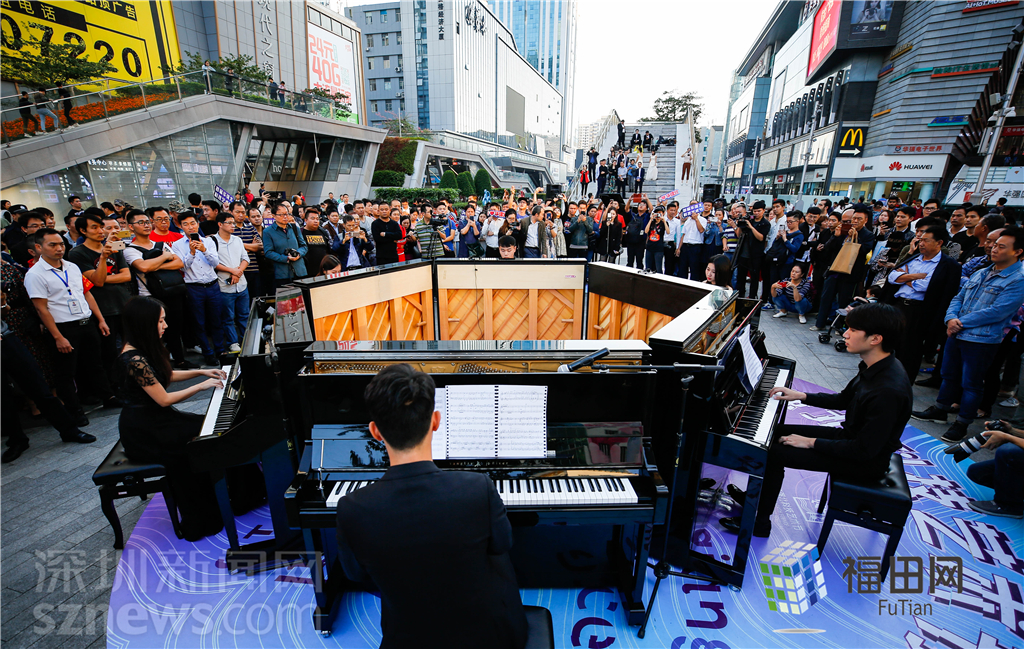 青年们在闭幕式上表演钢琴合奏,现场有众多市民围观.